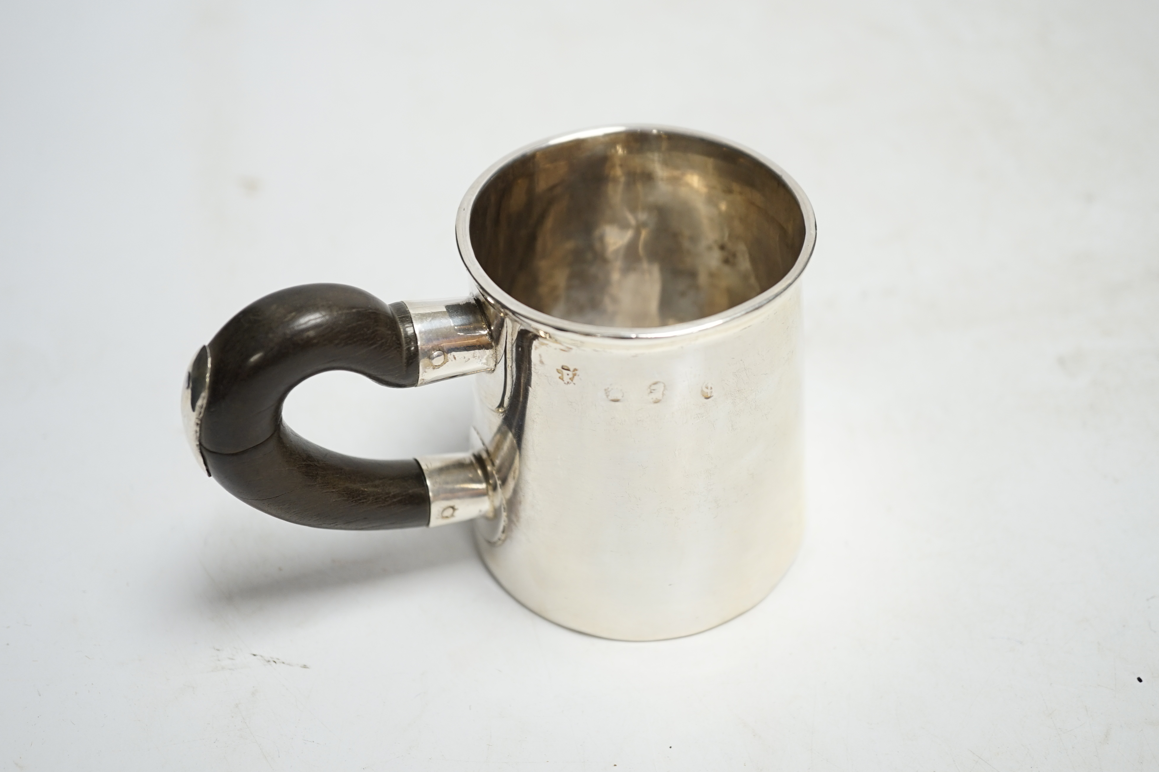 An early 18th century silver mug, with wooden handle, marks rubbed, height 78mm. Condition - poor